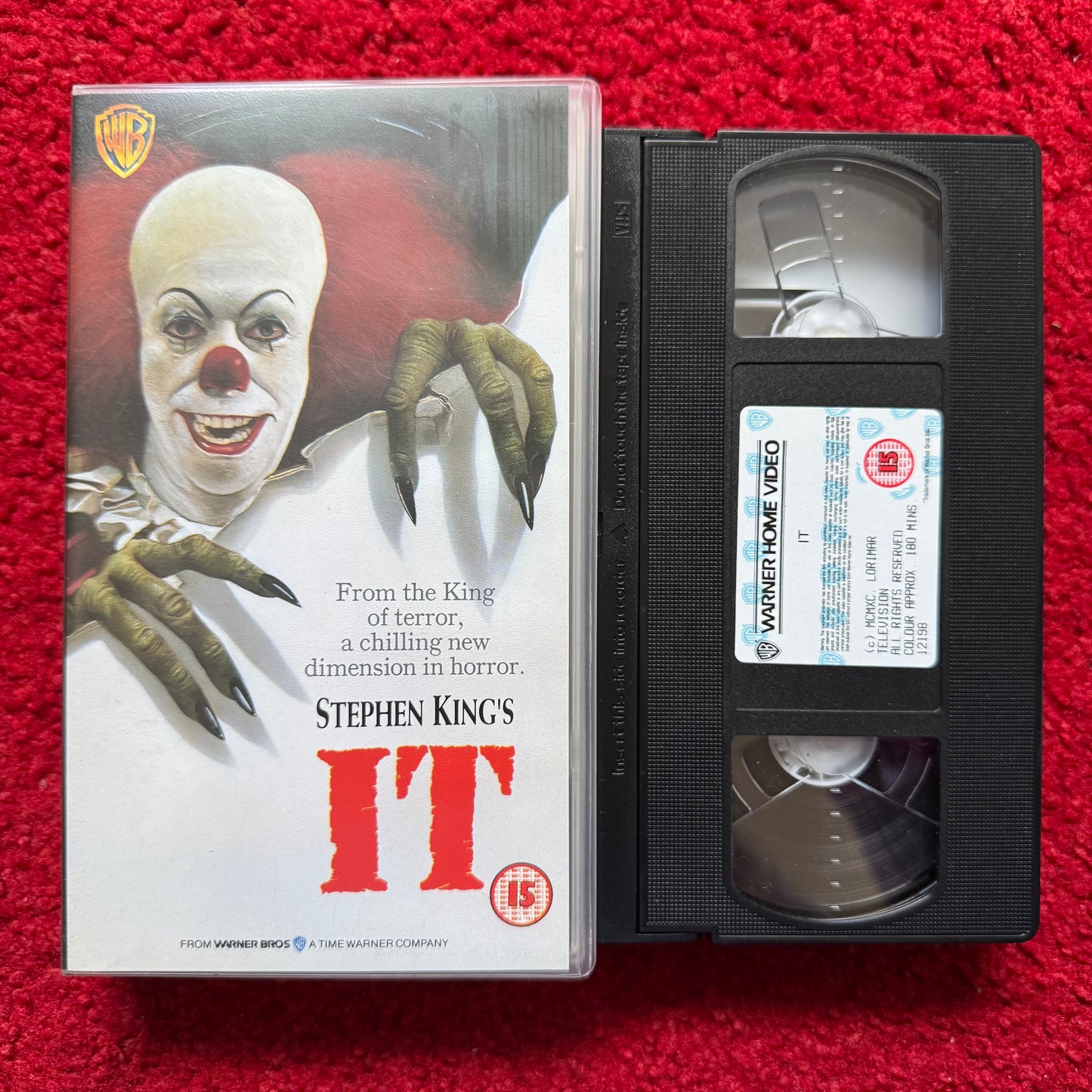 VHS tape of 'IT' by Stephen King with cover on a red background