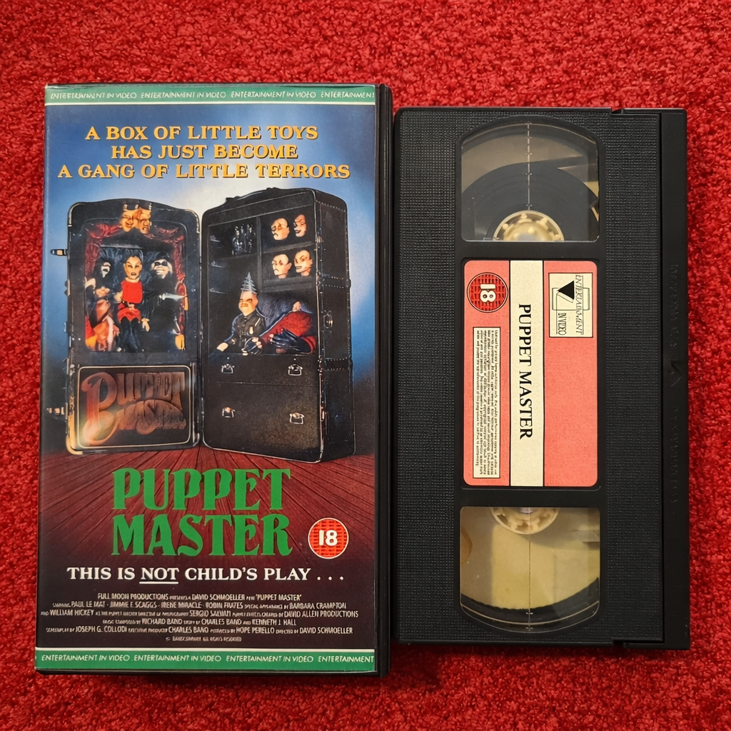 VHS tape of 'Puppet Master' with its packaging on a red background
