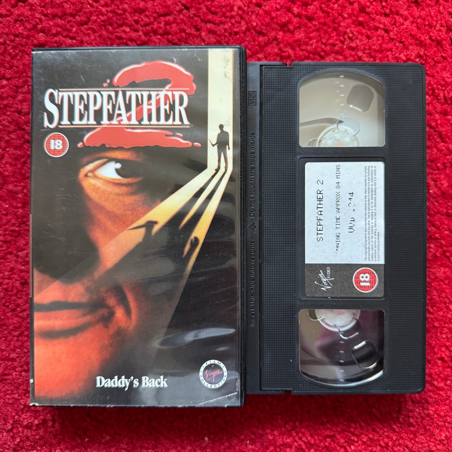 VHS tape of 'Stepfather' with its cover on a red background