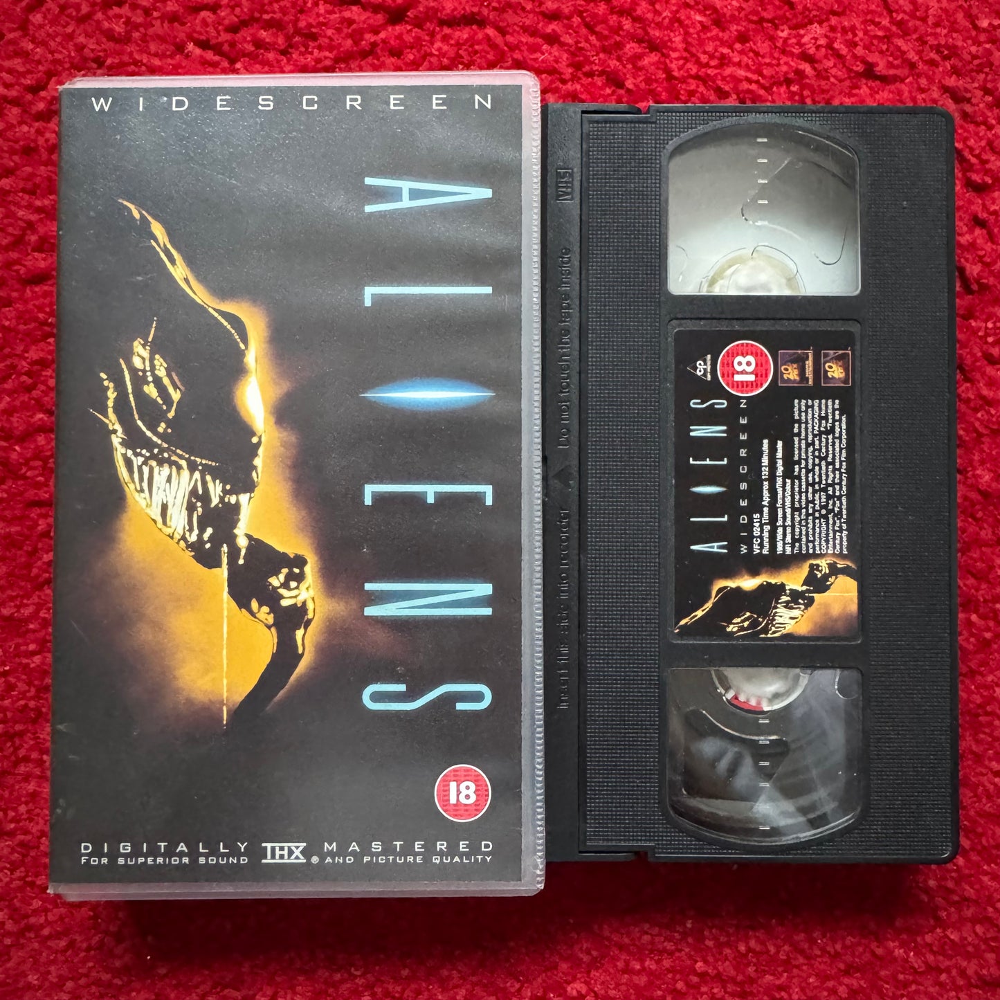 VHS tape of 'Aliens' with cover on a red background