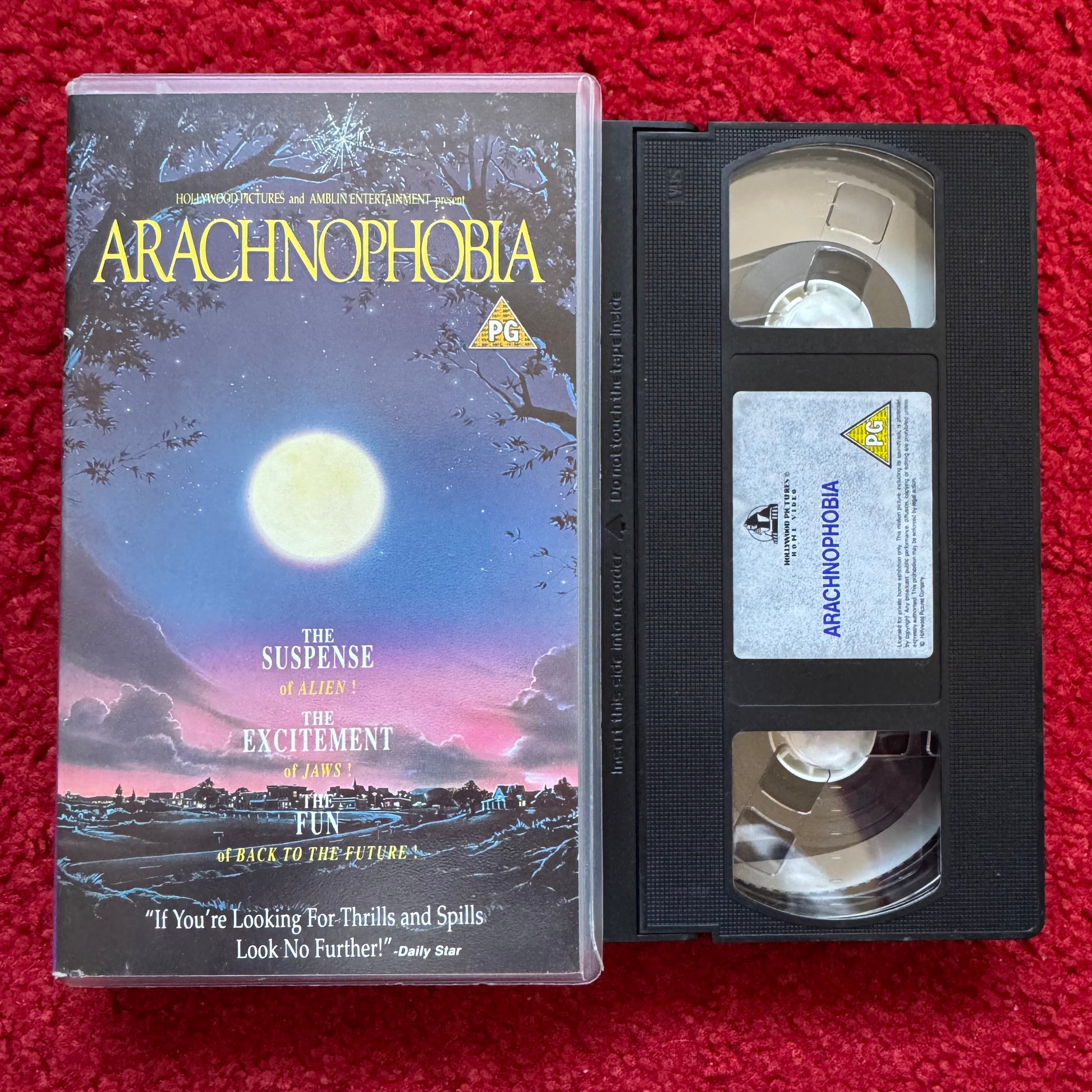 VHS tape of 'Arachnophobia' with its cover on a red background