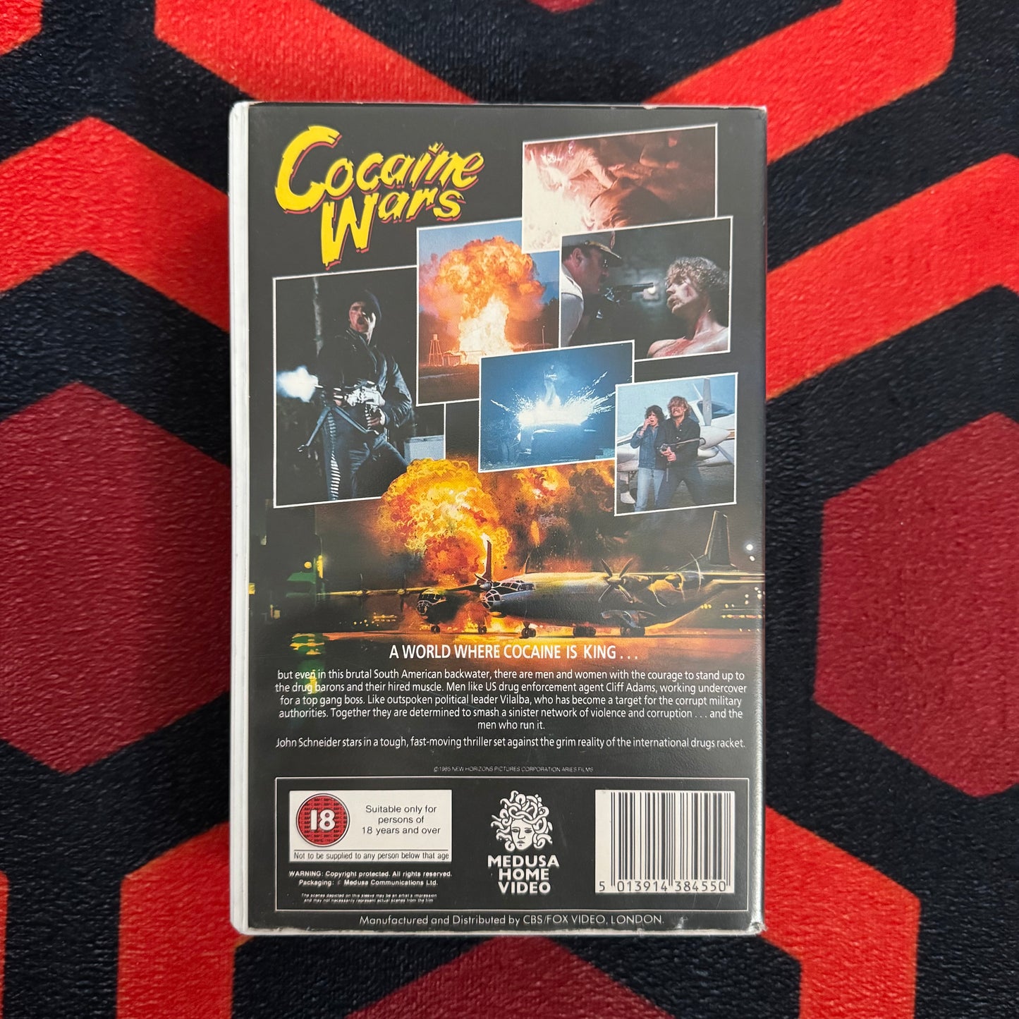 VHS tape cover of 'Cocaine Wars VHS' on a red and black chevron patterned background