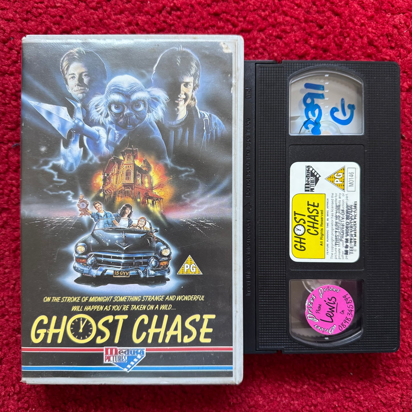 VHS tape of 'Ghost Chase' with cover on a red background