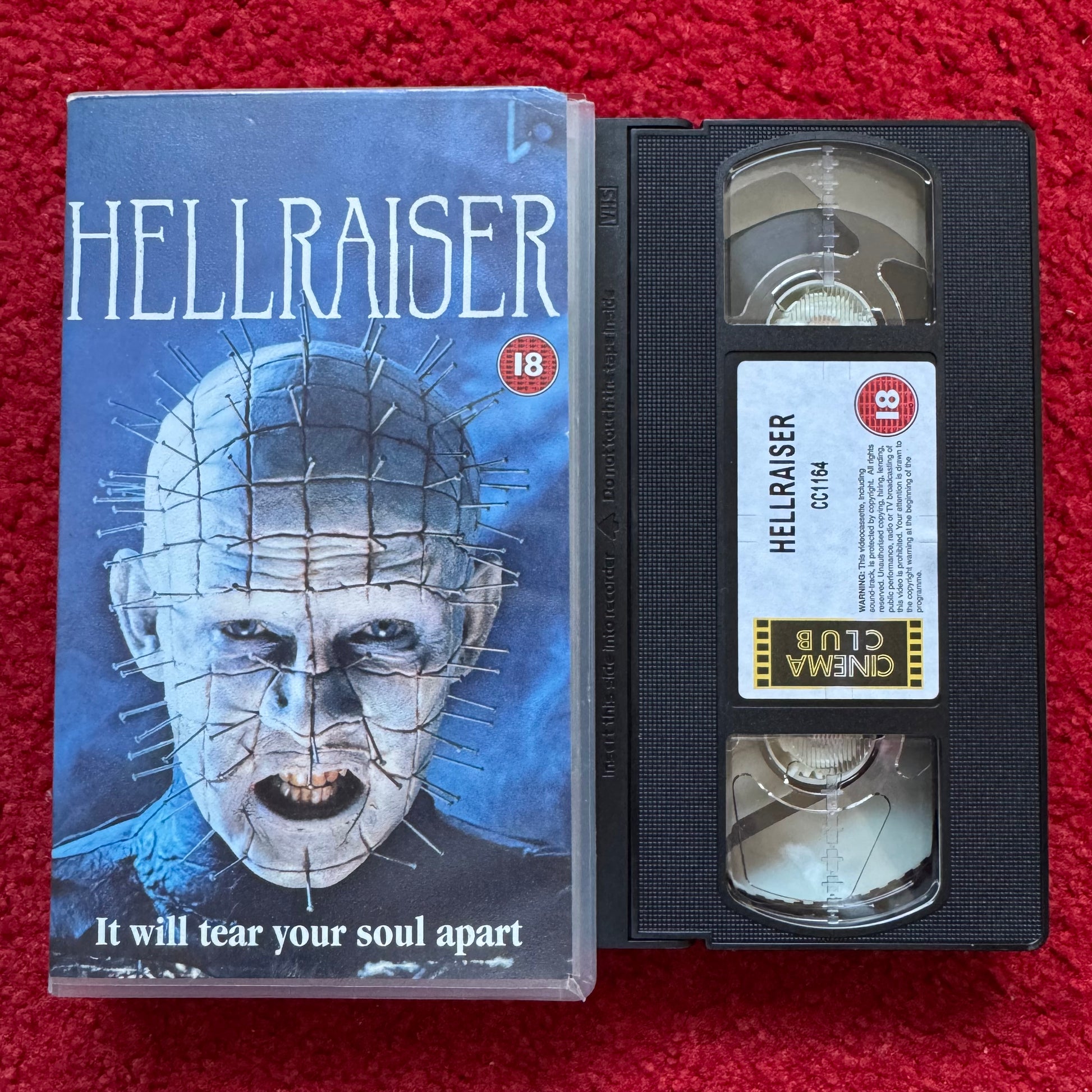 VHS tape of 'Hellraiser' with cover on a red background