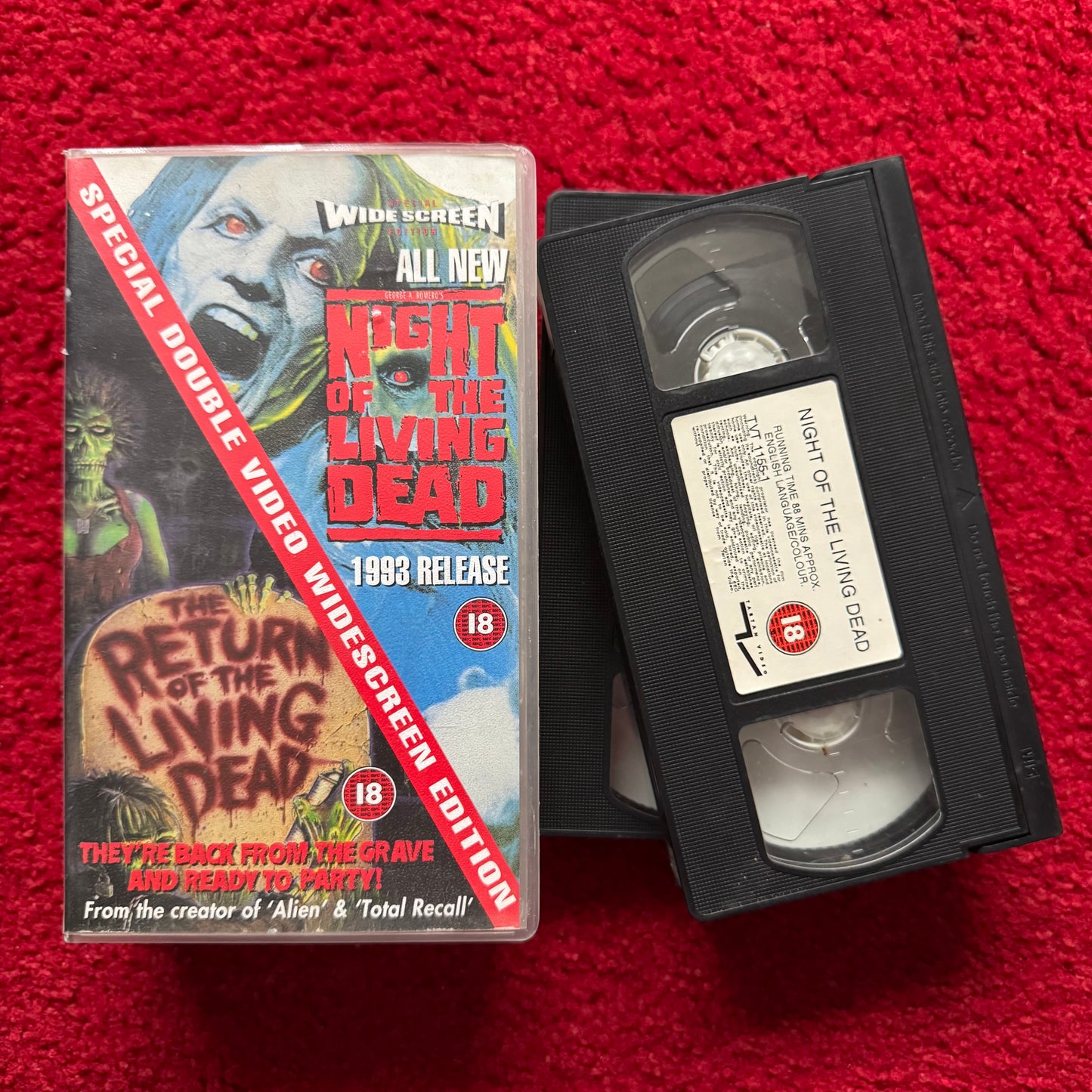 VHS tape of 'Night of the Living Dead' with packaging on a red background