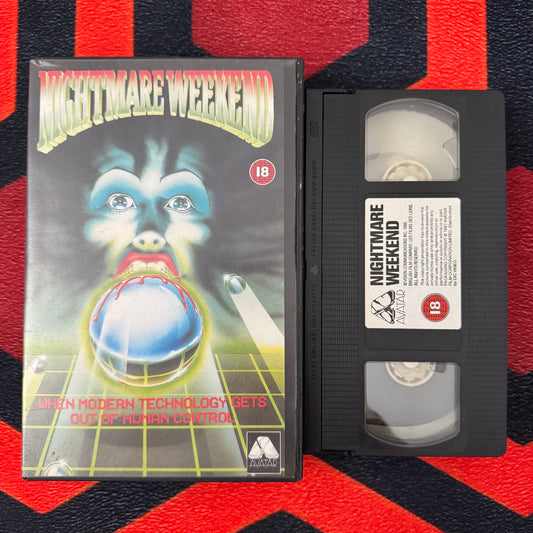VHS tape of 'Nightmare Weekend' with cover on a red and black patterned background