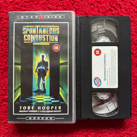 VHS tape of 'Spontaneous Combustion' with cover on a red textured background