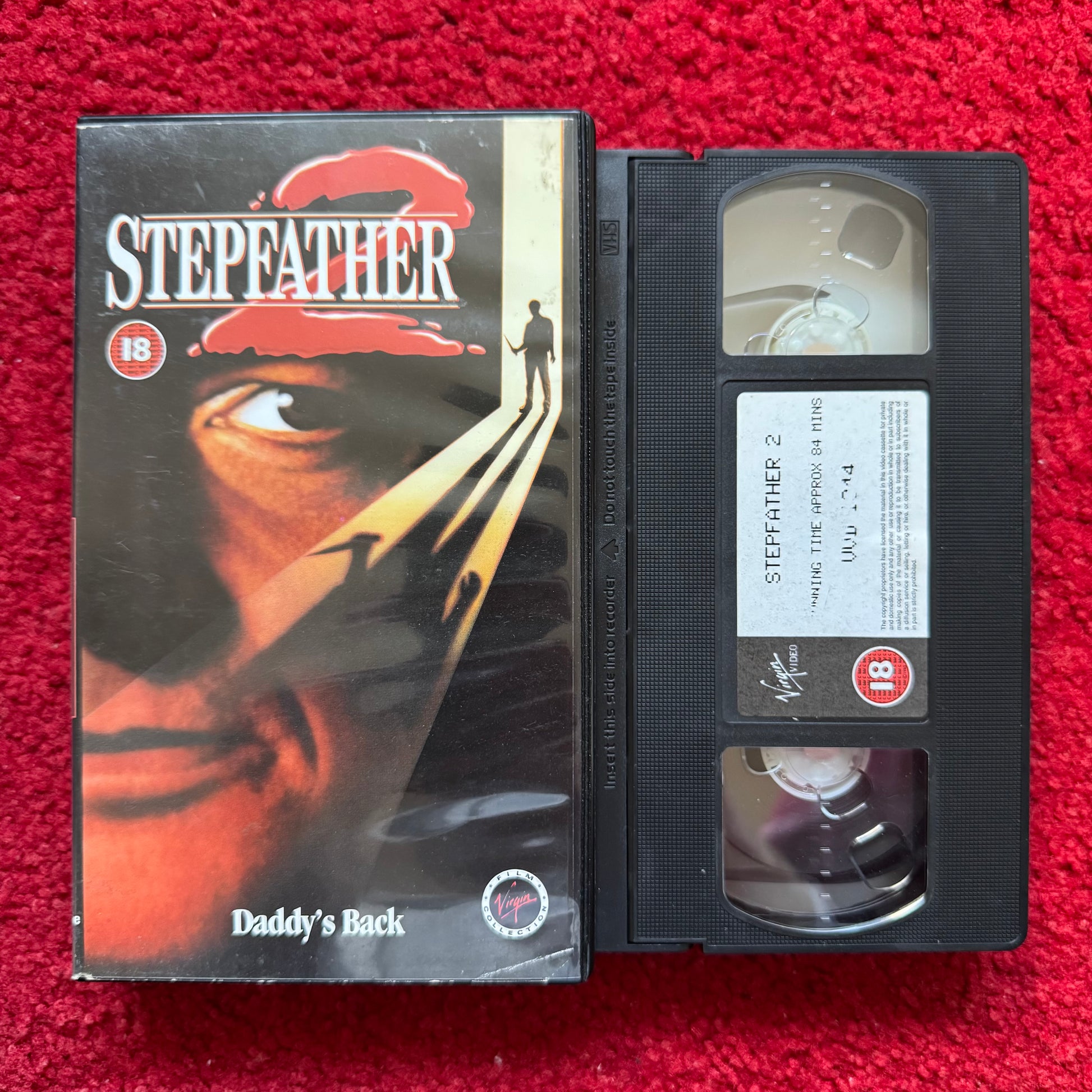VHS tape of 'Stepfather' with its cover on a red background