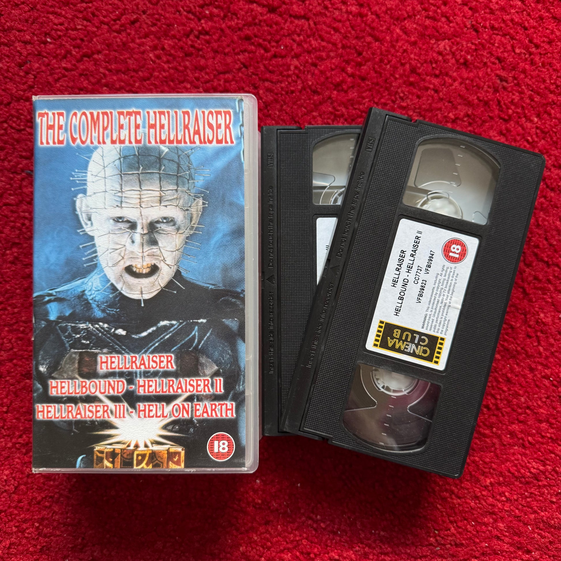 VHS tape of 'The Complete Hellraiser' series with cover on a red textured background